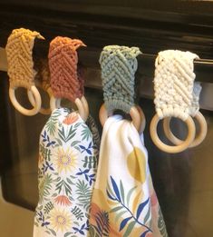 four rings are hanging from the handle of an oven door, with different patterns on them