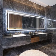 a bathroom with marble counter tops and two sinks in front of a wall mounted mirror