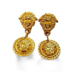 1990s. Vintage Gianni Versace gold tone medusa face motif dangle earrings. Must have Lady Gaga style jewelry piece. Great gift. For all vintage Versace lovers and collectors! Introducing a pair of vintage earrings from GIANNI VERSACE back in the 90's. Featuring 2 medusa heads each pair, dangling as you move. The signature logo engraved in the back. It shows some small rusted spots in the backside partially. Overall, these pieces are still shining well and are in a great vintage condition. You will love its elegant and stunning design in style over the decades. It will definitely be the best accent to your outfit for sure! Made in Italy Measurement: Length: 2.16"(5.5cm), Width 0.8"(2cm) *Free gift wrapping upon request. Please feel free to ask us any questions :) Lady Gaga Style, Medusa Face, Silver Versace Earrings, Versace Medusa Earrings, Versace Medusa Necklace, Versace Medusa Biggie Sunglasses, Vintage Versace Sunglasses, Versace Gold, Vintage Versace