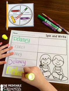 a child's hand is writing on a paper with markers and crayons