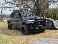 a large black truck parked in the grass