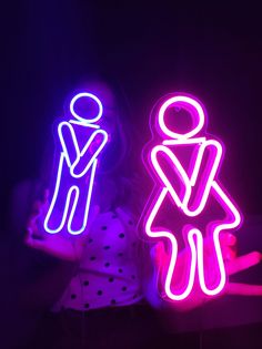 two neon signs that are shaped like people and one has a man and woman on it