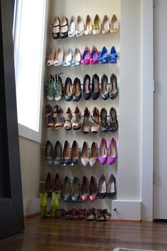 there are many pairs of shoes on the wall next to each other in this shoe rack