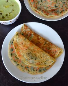 two white plates topped with food next to soup