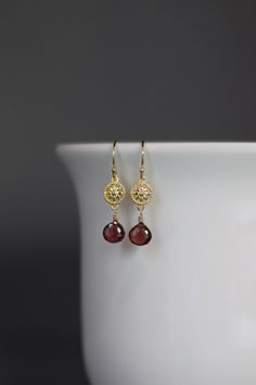 "Sweet micro faceted Red Garnet teardrops are wire wrapped with 14k gold filled wire onto bright 24k gold vermeil flower links.  These dangle from gold vermeil earwires. Choose from 18k gold vermeil balled gold earwires (as shown and sent with stoppers for the ends of the wires) or plain 24k gold vermeil leverback earwires (these close in the back). Perfect petite, lightweight everyday earrings!  Each pair of stones will vary slightly.  Gold flower link: 7x10mm Garnet teardrops: 7x7mm Total length of earrings: 1 1/4\" Length is approximate As the owner, maker, designer, and curator of this shop, I take great pride in providing you with jewelry that you will love to wear everyday, for special occasions, and for many years to come.  Please read my Shop Policies which contains important infor Gold Vintage Earrings, Red And Gold Earrings, Garnet Teardrop Earrings, Gold Wire Wrapped Earrings, Red Garnet Jewelry, Flower Earrings Gold, Gemstone Earrings Gold, Pretty Jewelry Necklaces, Garnet And Gold