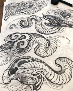 an ink drawing of two dragon heads on top of a piece of paper with a marker