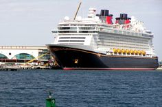 a large cruise ship in the water next to a dock with a green buoy