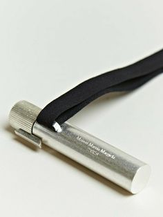 an electronic device with a black lanyard attached to it's back end on a white surface