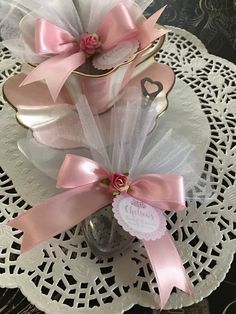 pink and white flowers in a glass vase on a doily with a name tag