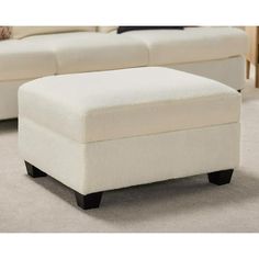 a white ottoman sitting on top of a carpeted floor