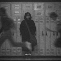 three people are standing in front of lockers