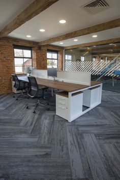 an empty office with two desks and chairs in the middle of the room,