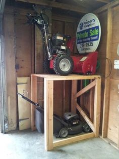 the inside of a storage shed with a lawn mower