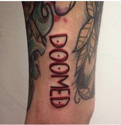 a close up of a person's leg with tattoos on it and the words doodled written in red ink