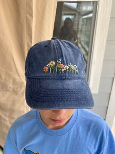 a boy wearing a blue hat with flowers on it's brimmed cap