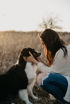 a woman petting a dog in a field