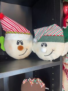 two snowmen with hats and candy canes on their heads