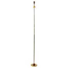 an antique brass floor lamp with a red glass shade on the top and a metal base