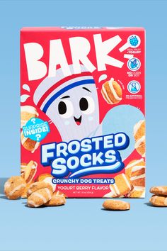 a box of frosted cookies sitting on top of a blue surface with an image of a marshmallow in the background