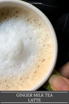 a person holding a cup of coffee with the text ginger milk tea latte