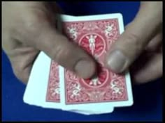 a person holding two playing cards in their hands