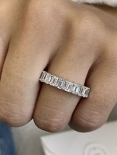 a woman's hand with a wedding band on it and the ring has three baguetts