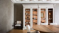 a dining room table and chairs with built - in bookcases