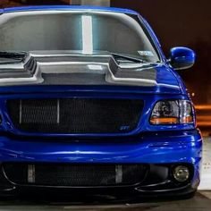 the front end of a blue truck parked in a garage