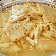 a bowl filled with chicken and gravy on top of a table