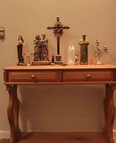 a wooden table topped with lots of figurines and crosses on top of it