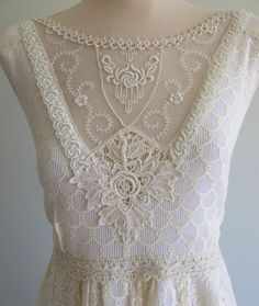 the back of a white dress on a mannequin headdress with lace and beads