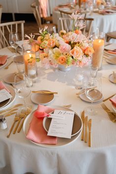 the table is set with flowers, candles and place settings for an elegant wedding reception