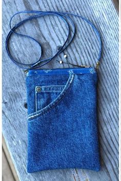 a small blue purse sitting on top of a wooden table next to a cell phone