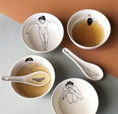 three bowls and spoons with drawings on them