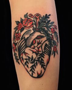 a heart tattoo with flowers and birds on the inside of it, surrounded by leaves