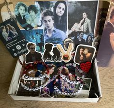 an open box with pictures and magnets on the inside, along with other items