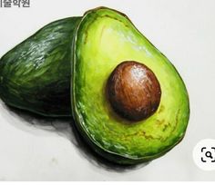 an avocado cut in half on a white surface with chinese characters above it