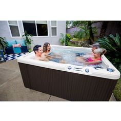 three children are playing in an outdoor hot tub