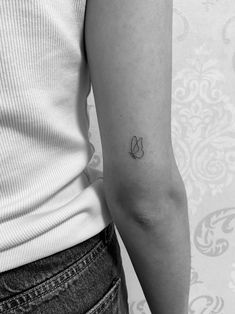 a woman's arm with a small butterfly tattoo on the left side of her arm