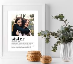 two women hugging each other in front of a white framed photo with the words sister on it