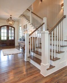 an entryway with wooden floors and white banisters on the second floor is shown