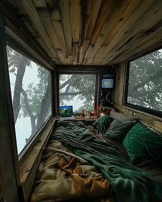 a bed in a room with two windows and a blanket on top of the bed