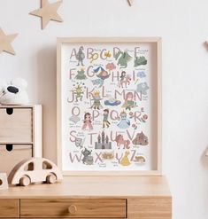 a wooden dresser with a toy car, teddy bear and star shaped wall hangings