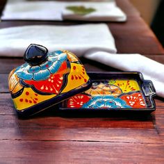 two colorful dishes sitting on top of a wooden table