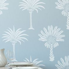 a table with plates and silverware on it in front of a wallpapered background