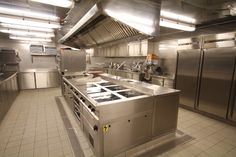 an industrial kitchen with stainless steel appliances and tile flooring