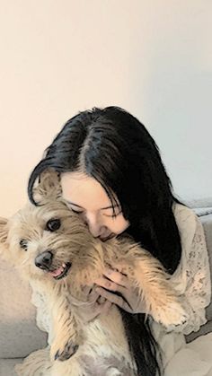 a woman sitting on a couch holding a dog