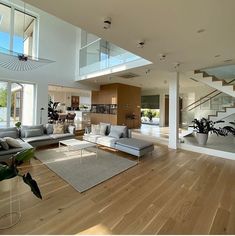 a living room filled with lots of furniture and large open floor to ceiling glass windows