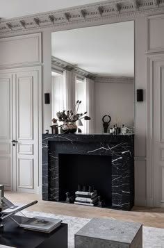 a living room filled with furniture and a fire place in front of a large mirror