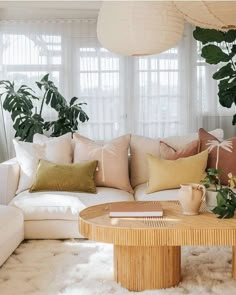 a living room filled with lots of furniture and plants